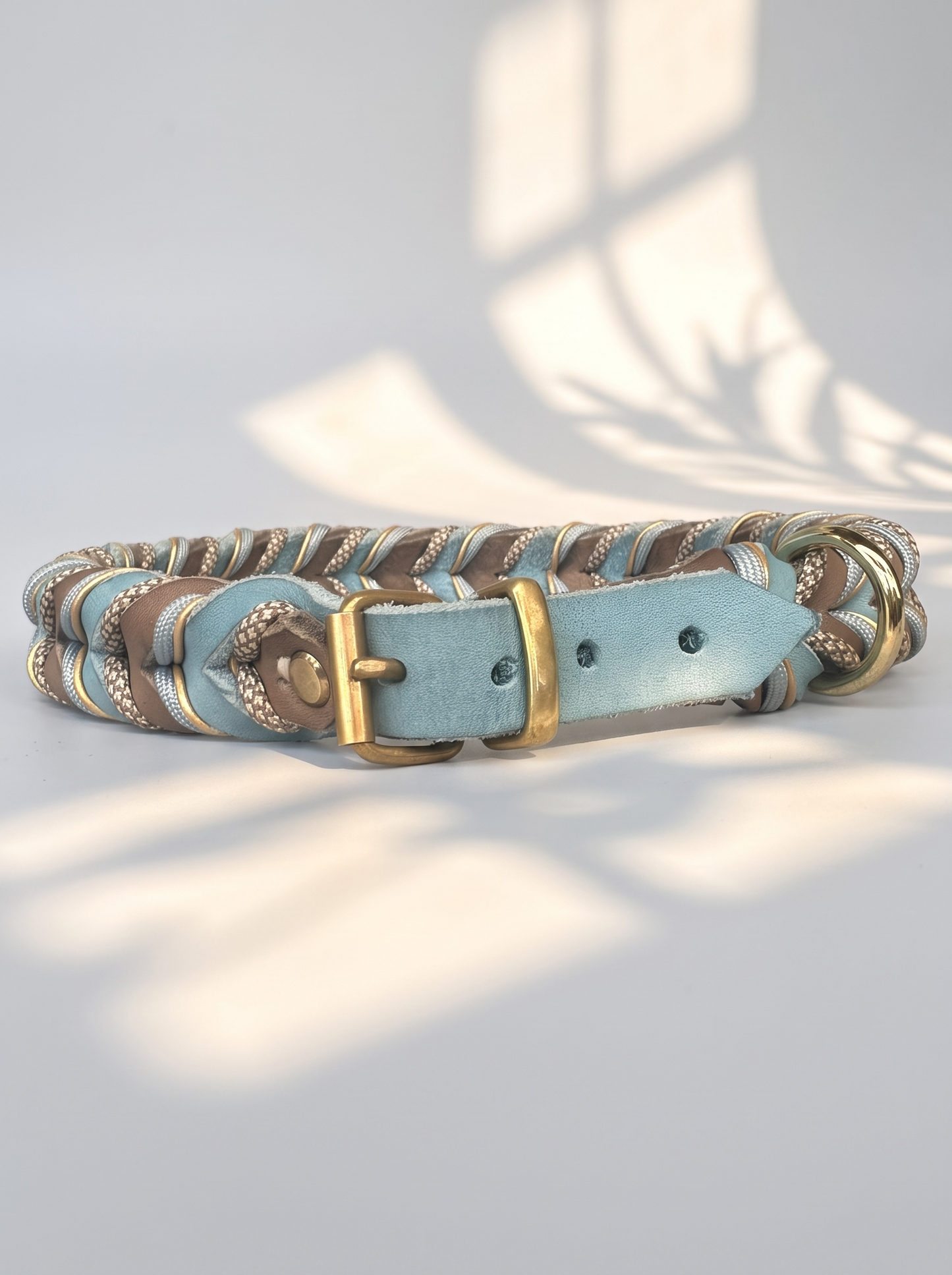 Lederhalsband geflochten in blau und braun mit beigen Details. Handgefertigt und individuell anpassbar. Ansicht Vorne Rollschnalle Messing
