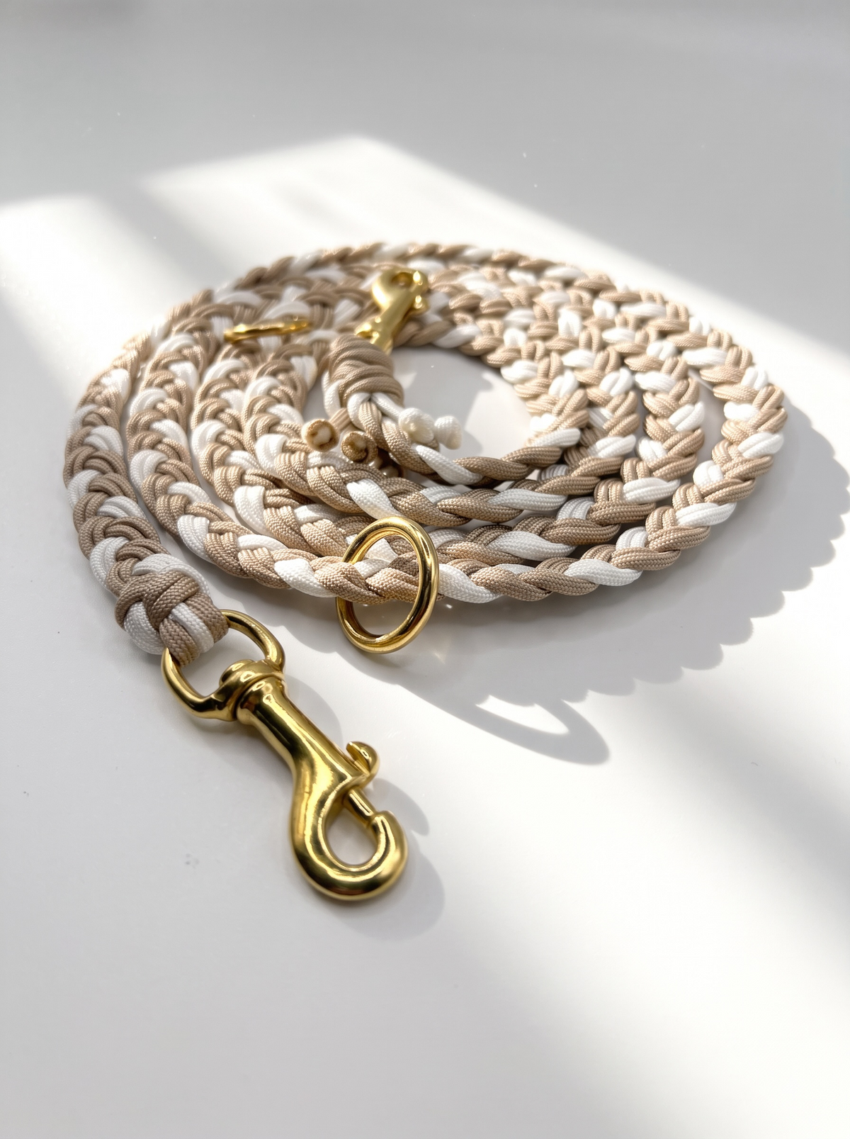 Hundeleine geflochten aus Paracord Typ 3 in snow weiß und Café Latte beige mit goldenen Details Gesamtansicht Bolzenkarabiner Messing 