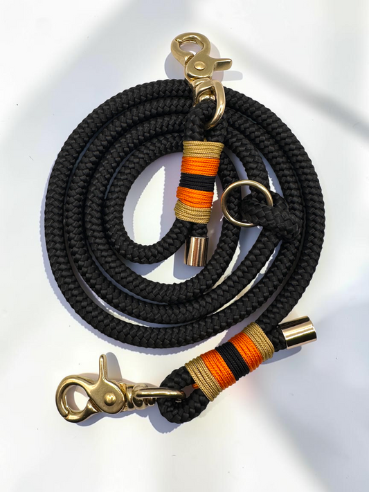 Hundeleine aus 10mm starken Tau in der Farbe Schwarz. Umwicklung in Gold,orange und schwarz. Beschläge in Gold Messing. Perfekte Herbstleine für hunde