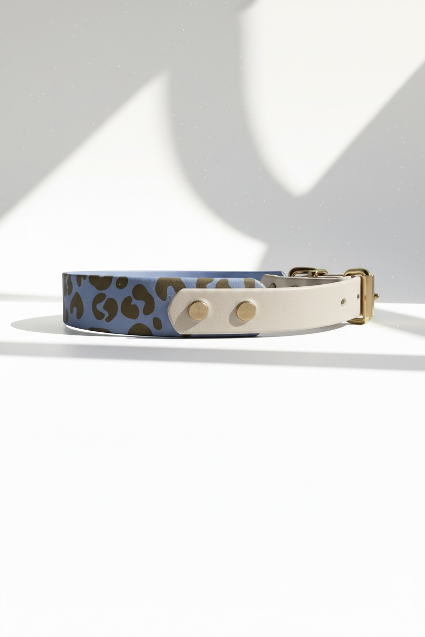 Leoparden Hundehalsband aus BioThane in Arctic Wolf und Polar Blau mit goldfarbenen Messingbeschlägen, Seitenansicht des personalisierbaren Halsbandes im Leo Design. Handgefertigtes BioThane Hundehalsband wahlweise als verstellbares Halsband oder Zugstopp Halsband erhältlich. Individuell konfigurierbar mit wählbarer Breite, anpassbarer Beschlagfarbe sowie optionaler Namensgravur oder Logo Gravur. Strapazierfähiges, wasserfestes und pflegeleichtes Hundehalsband für kleine, mittlere und große Hunde, passend z