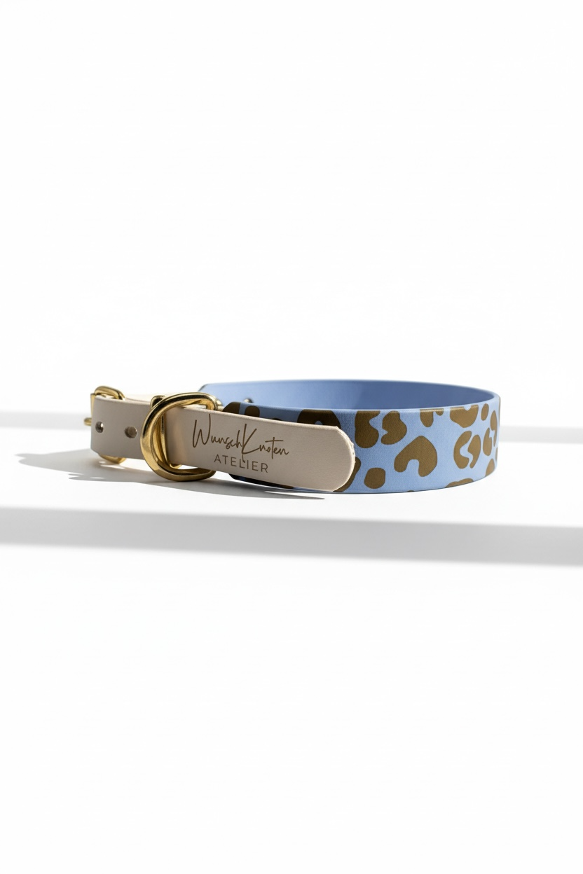 Leoparden Hundehalsband aus BioThane in Arctic Wolf und Polar Blau mit goldfarbenen Messingbeschlägen, Seitenansicht mit Logo-Gravur. Individuell handgefertigtes Hundehalsband im Leo Design, personalisierbar mit Namensgravur oder Logo Gravur. Wahlweise als verstellbares Halsband oder Zugstopp Halsband erhältlich. Breite, Verschlussart und Beschlagfarbe frei wählbar. Passend kombinierbar mit Leopardenleine, Länge und Verstellmöglichkeiten individuell konfigurierbar.