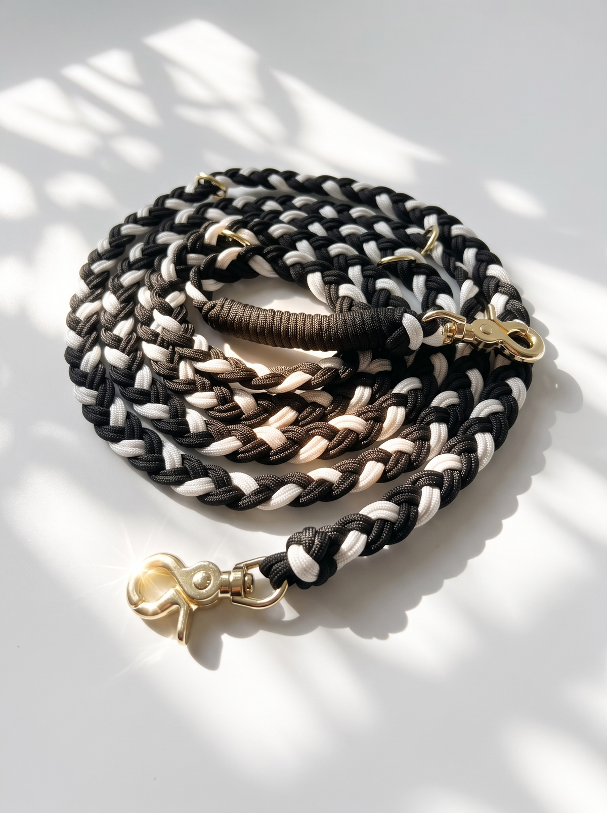 Hundeleine aus schwarzem und weißen Paracord Typ 3 geflochten mit goldenen Details in herbstlichen Farben. Scherenkarabiner Gold 