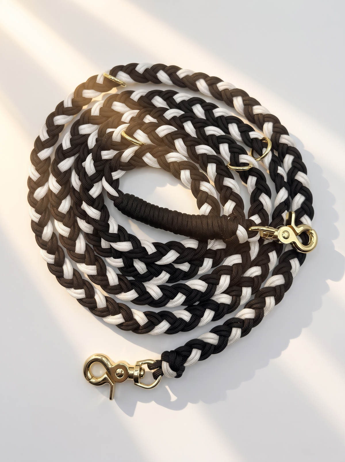 Hundeleine aus schwarzem und weißen Paracord Typ 3 geflochten mit goldenen Details in herbstlichen Farben. Draufsicht 