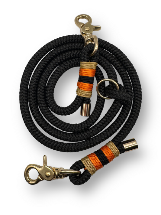 Hundeleine aus 10mm starken Tau in der Farbe Schwarz. Umwicklung in Gold,orange und schwarz. Beschläge in Gold Messing.