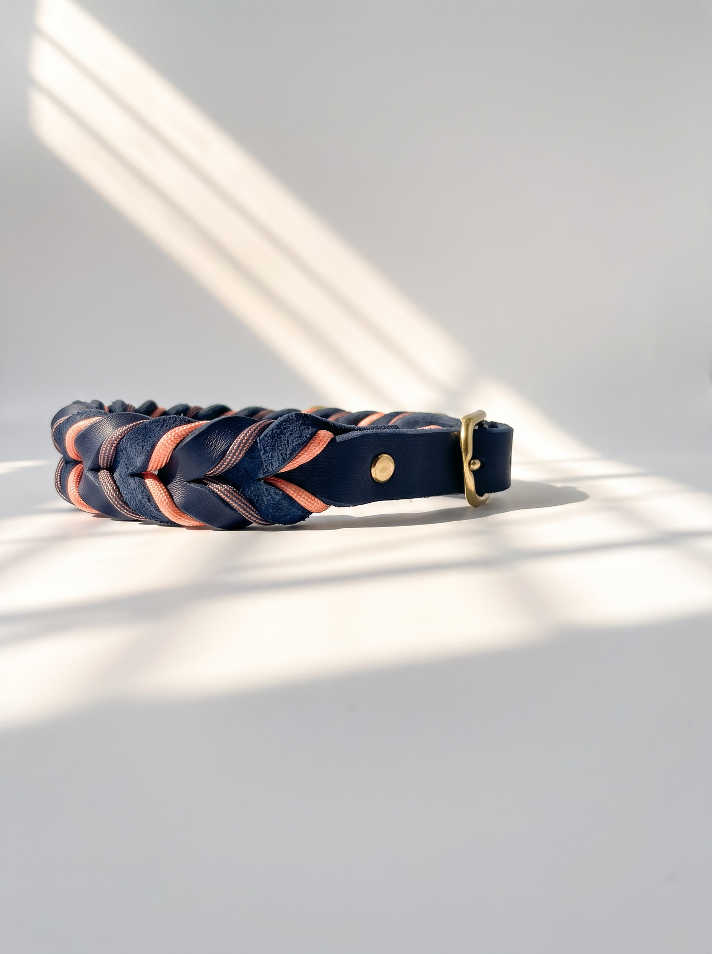 Lederhalsband geflochten aus Fettleder in der Farbe Dunkelblau mit rosé farbenen Details und goldenen Beschlägen. Individuell anpassbar in breite. Ansicht Halsband seiten