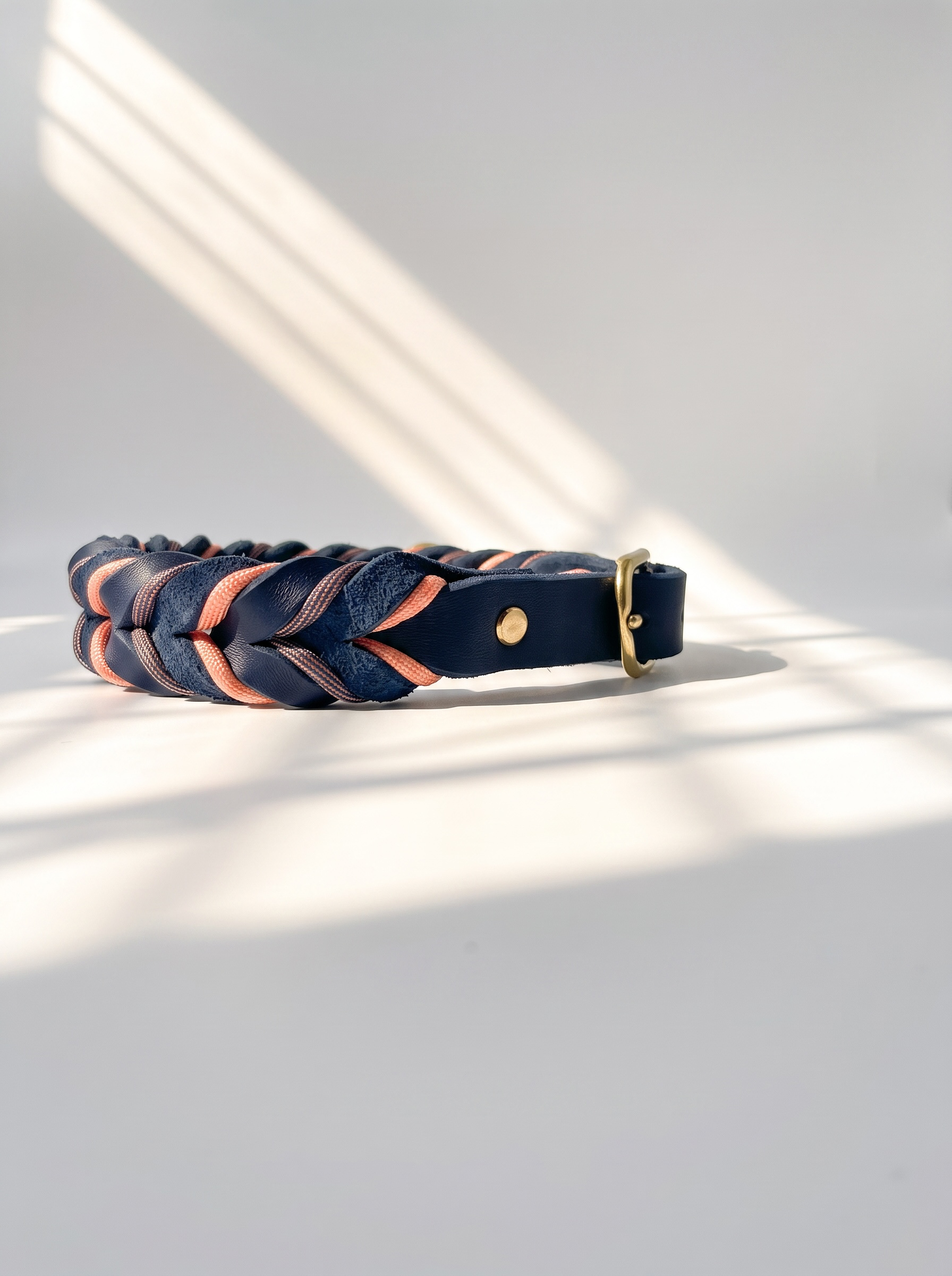 Lederhalsband geflochten aus Fettleder in der Farbe Dunkelblau mit rosé farbenen Details und goldenen Beschlägen. Individuell anpassbar in breite. Ansicht Halsband seiten