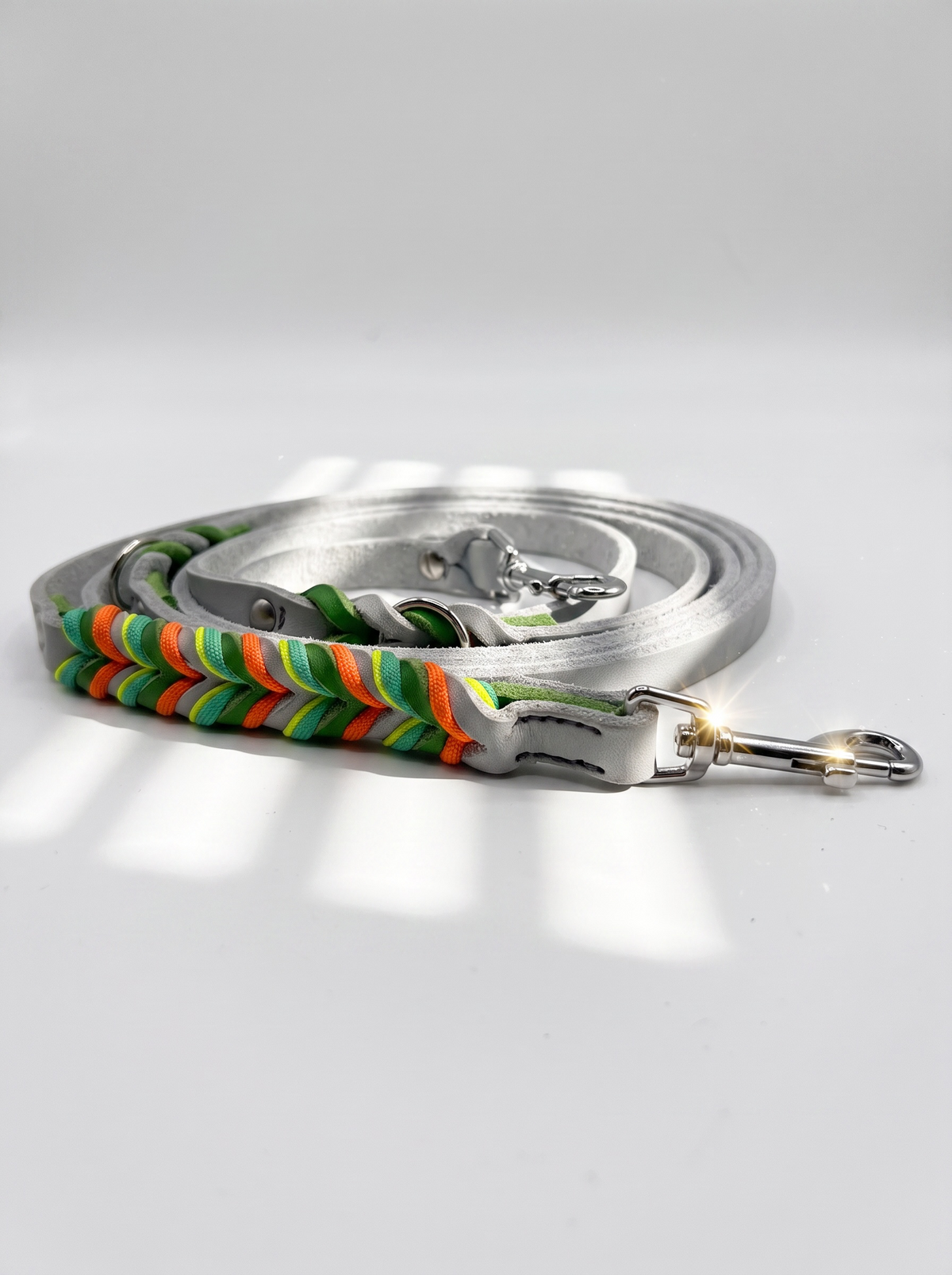Hundeleine geflochten aus Leder in den Farben silbergrau und grün. Geflochten mit orange, gelb und grünen Details. Ansicht der Leine 