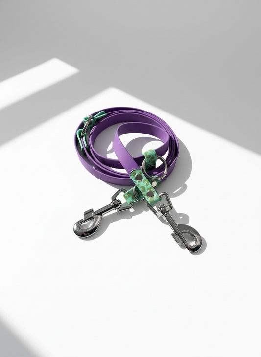 Leoparden Hundeleine aus BioThane in Caribbean Grün und Amethyst Orchid mit goldfarbenen Messingbeschlägen, Vogelperspektive der verstellbaren Hundeleine im Leo Design. Handgefertigte BioThane Hundeleine mit individuell wählbarer Leinenlänge, verschiedenen Verstellmöglichkeiten und anpassbarer Beschlagfarbe. Robuste, wasserfeste und pflegeleichte Hundeleine für kleine, mittlere und große Hunde, passend zum Leopardenhalsband oder als personalisierbares Hundeset erhältlich, ideal für Alltag, Training und Spaz