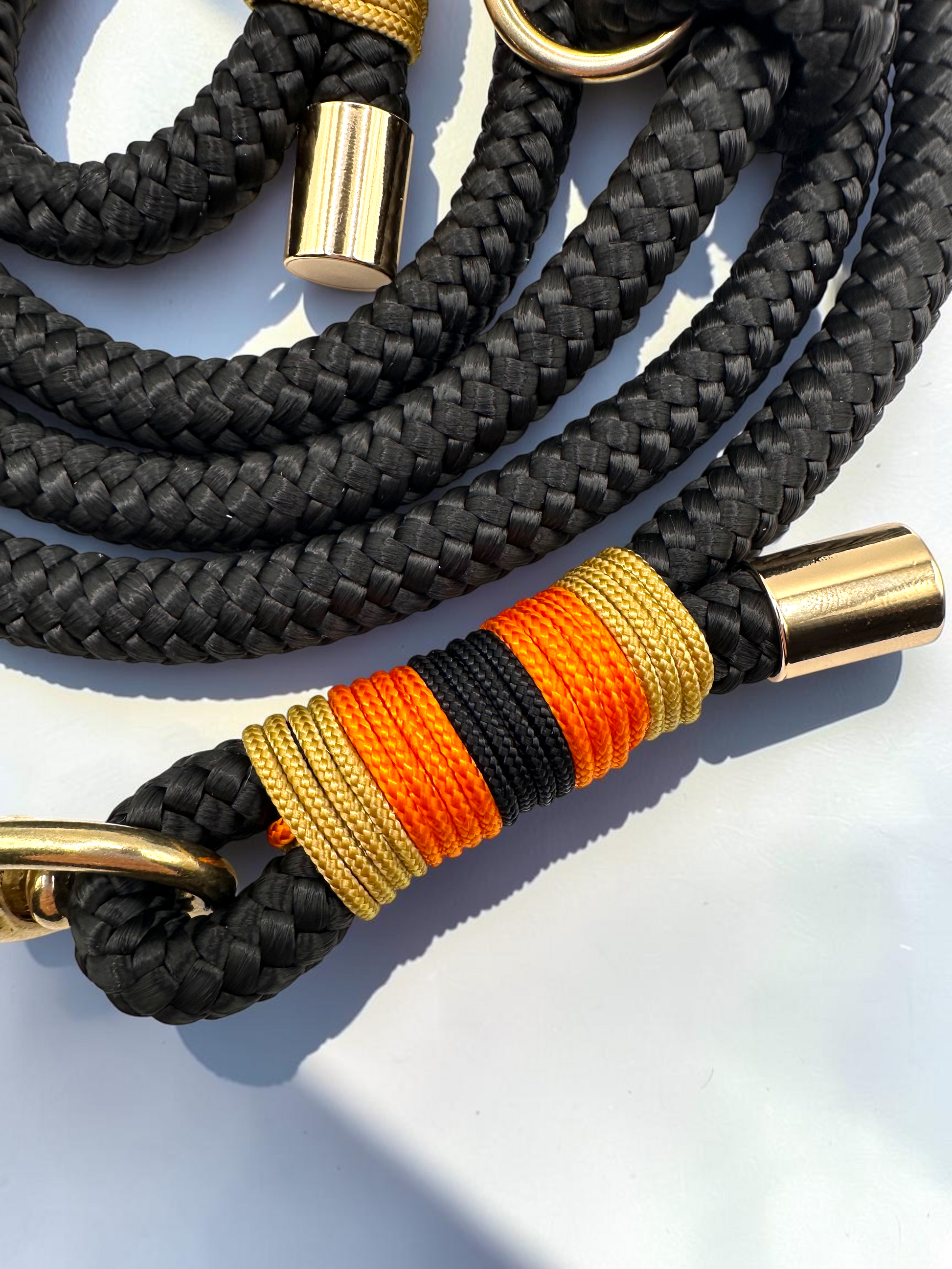 Hundeleine aus 10mm starken Tau in der Farbe Schwarz. Umwicklung in Gold,orange und schwarz. Beschläge in Gold Messing. Perfekte Herbstleine für hunde. Details der Umwicklung 