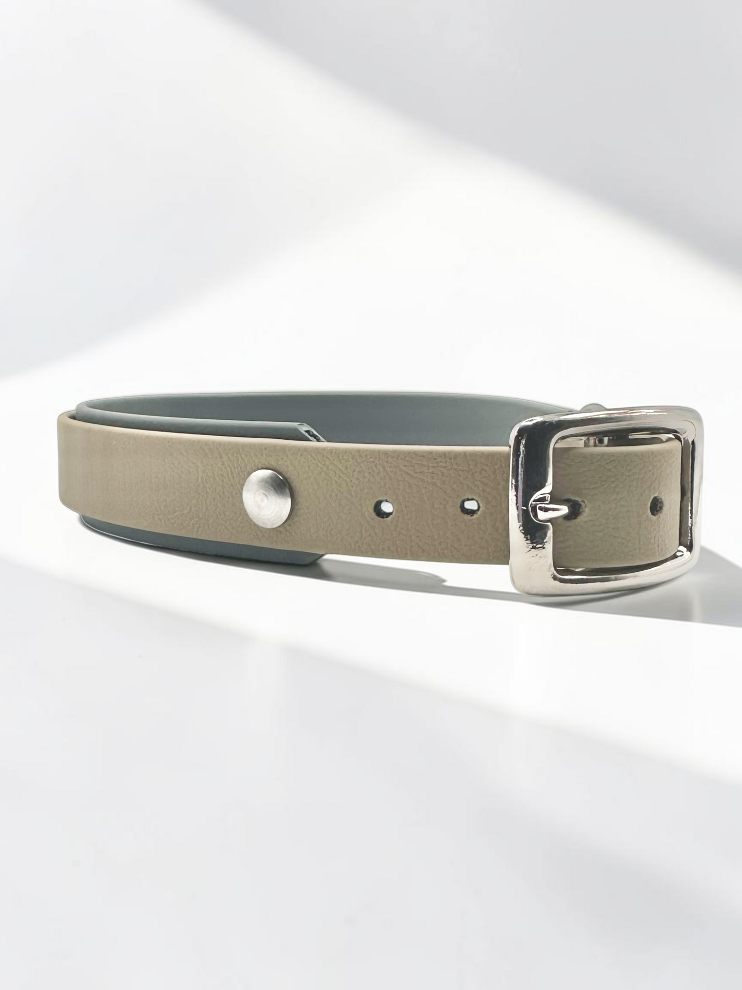 Handgefertigtes BioThane Halsband LINEA in Beige x Dunkelgrau – schräge Vorderansicht mit hochwertiger Doppelstegschnalle in Silber und zweifarbigem BioThane-Design.