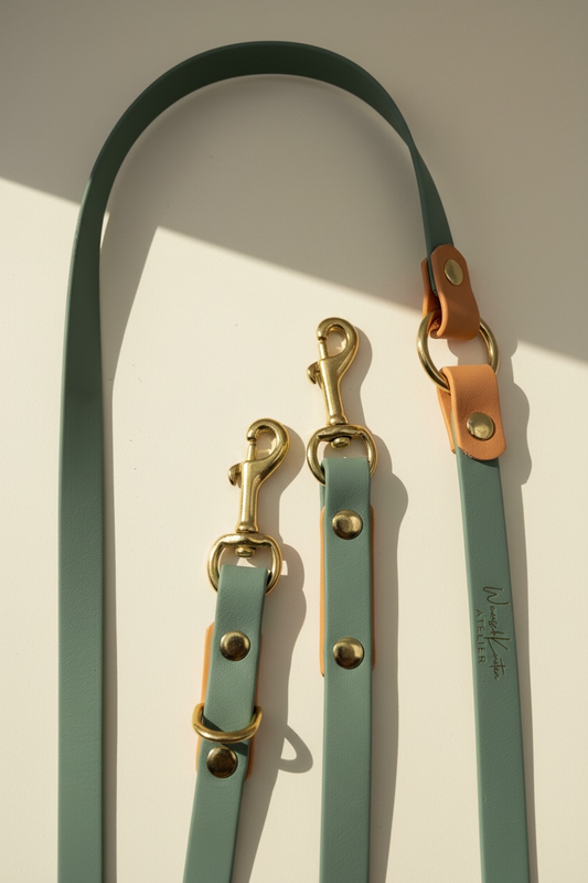 Detailaufnahme der handgemachten Biothane Hundeleine in Salbeigrün mit goldenem Glimmer – Fokus auf Gold-Karabiner und Verstellmöglichkeiten der individuell konfigurierbaren Leine