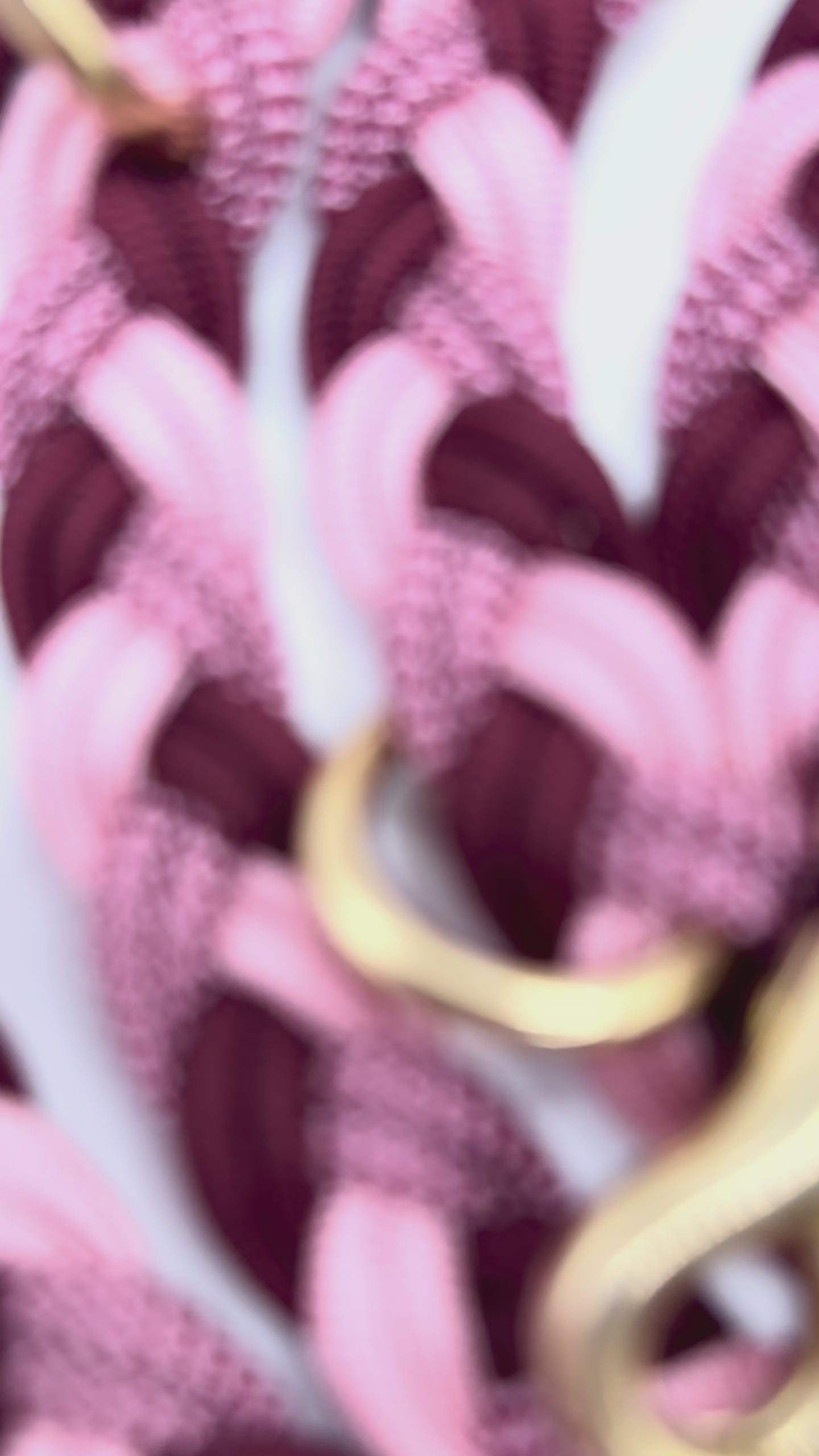 Paracordleine in rosa, rot und burgundy geflochten mit Messing Beschlägen. Aufnahmen von den Details der Leine 